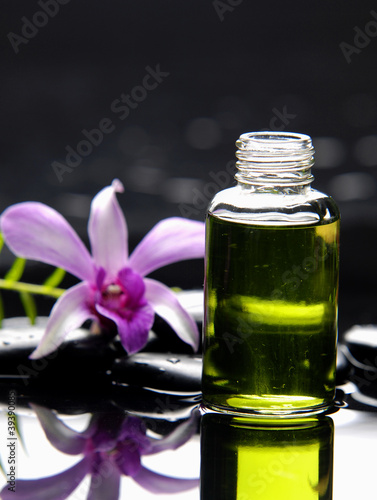 bottles of aromatic oil and fern with orchid