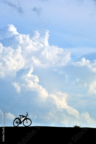 Silhouette of bicycle on the hill with Blue Sky