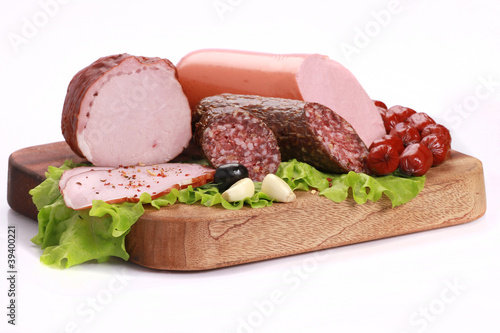 Still Life with sausages, salami and ham on a wooden table