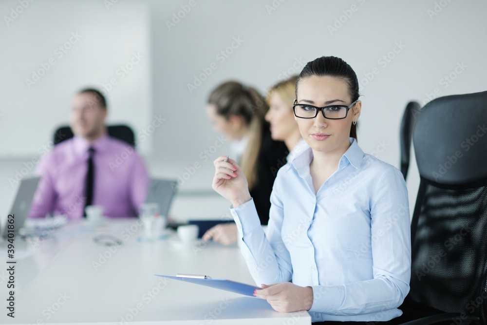 business woman standing with her staff in background business woman standing with her staff in background