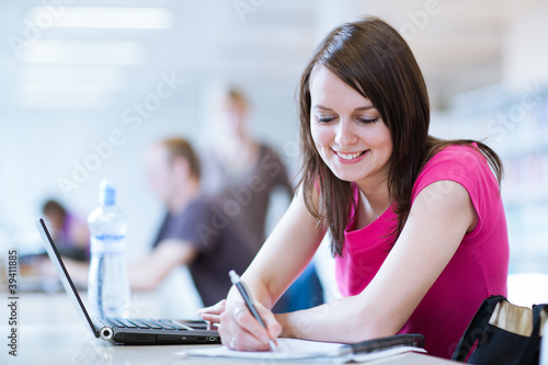 in the library - pretty female student with laptop and books