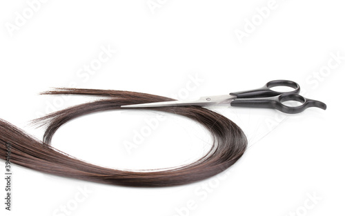 Shiny brown hair and hair cutting shears isolated on white