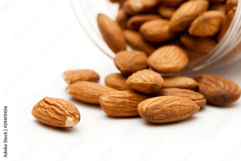 Almonds in the plastic jar on white Almonds in the plastic jar on white