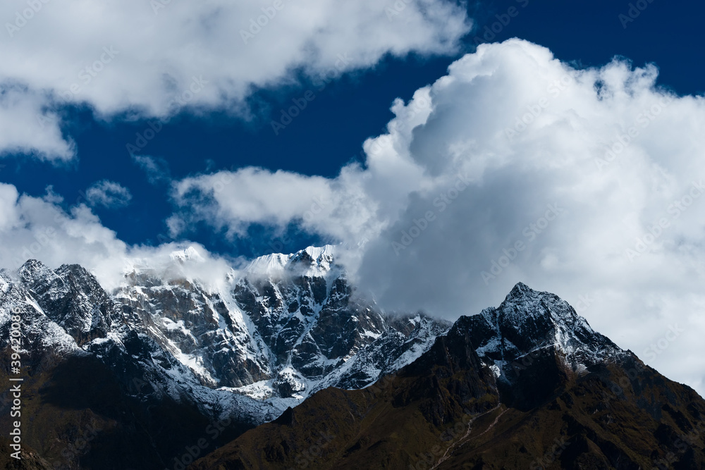 Snowed up mountain range and clouds in Himalayas