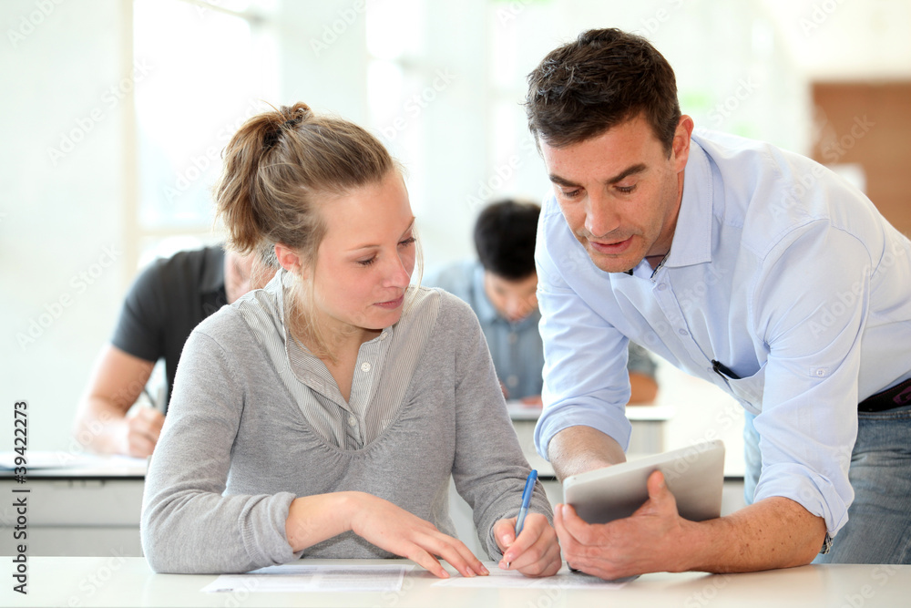 Teacher with student girl writing assignment Teacher with student girl writing assignment