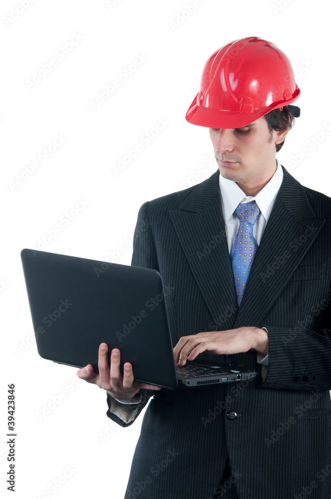 Young engineer with red helmet working on the notebook Young engineer with red helmet working on the notebook