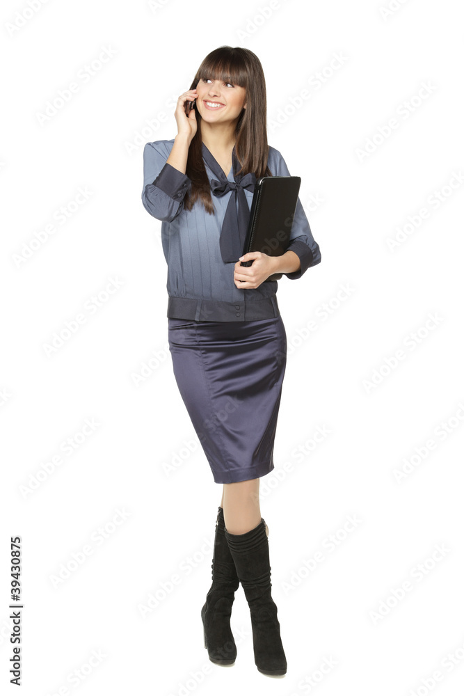 Full length of woman standing with laptop talking on cellphone Full length of woman standing with laptop talking on cellphone