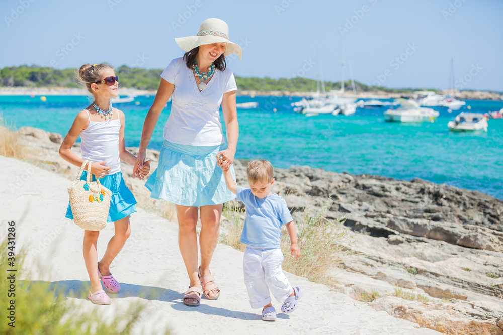 Family of three walking along tropical beach Family of three walking along tropical beach