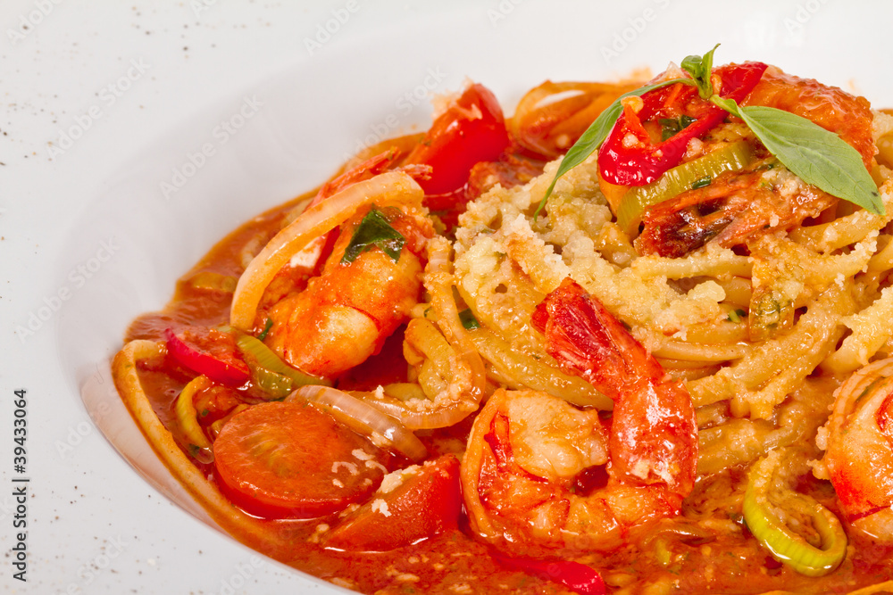 A plate of linguini with sauteed shrimp, tomato, chili and oliv A plate of linguini with sauteed shrimp, tomato, chili and oliv