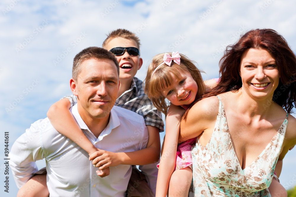 Happy family on a meadow in summer Happy family on a meadow in summer