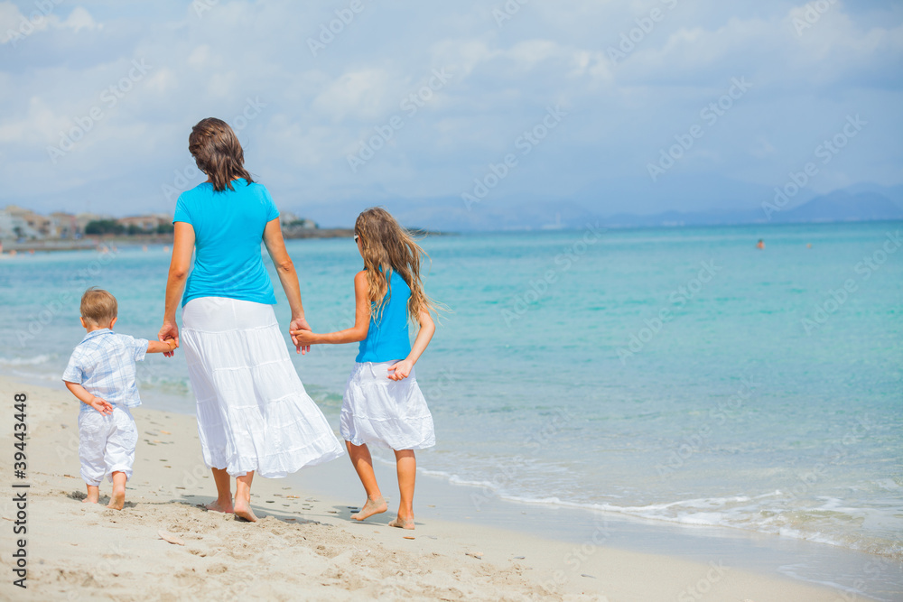 Mother and two kids having fun on beach