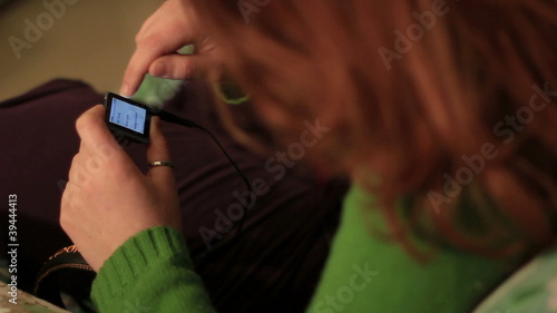 Redheaded woman uses an mp3 player photo