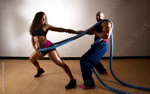 Young Woman and Man working out together in a Gym