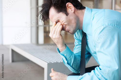 Frustrated businessman sitting on a bench