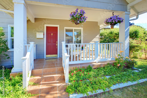 Photography Grey old house front porch exterior with red door.