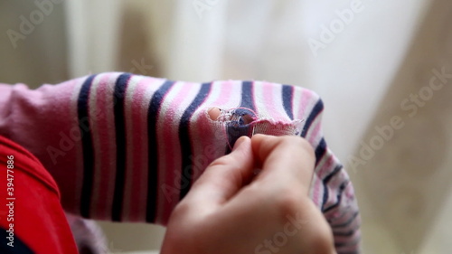woman sews up the hole with a needle