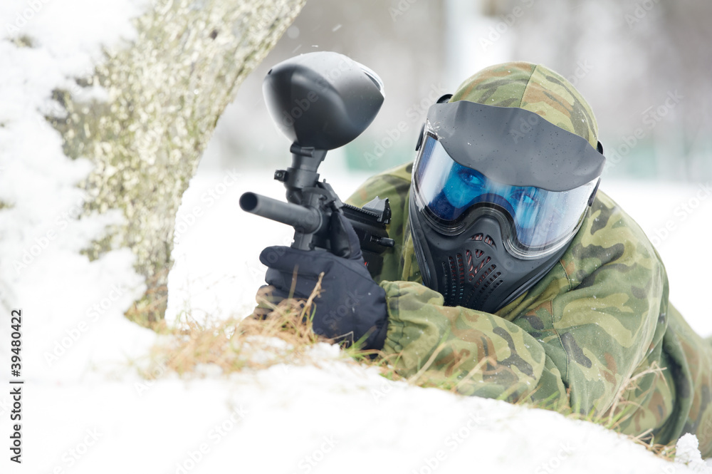 paintball player with marker at winter outdoors paintball player with marker at winter outdoors