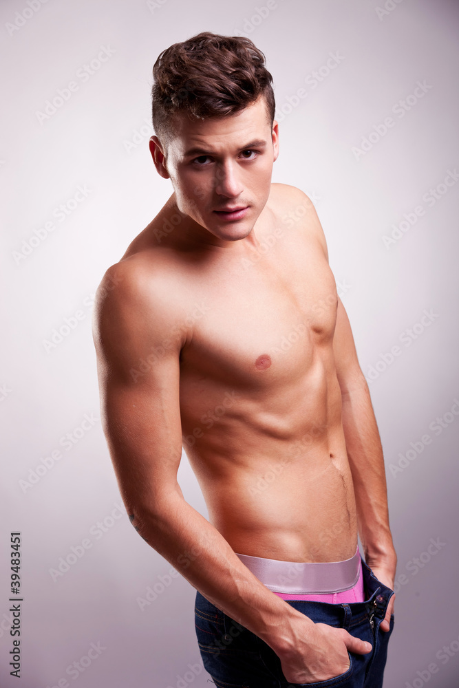 slim and muscular man posing on gray slim and muscular man posing on gray