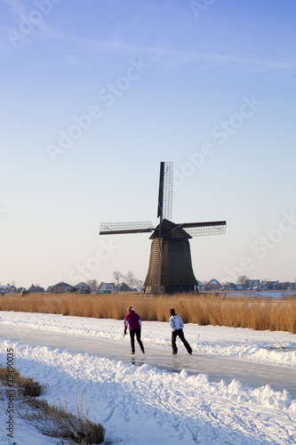 Windmill in winter time with snow, ice and blue sky