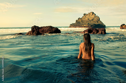 Chica sentada en la orilla del mar
