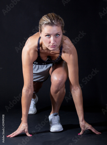 Beautiful young woman in a sprinters crouch