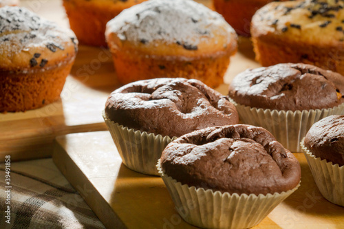 Chocolate and vanilla muffins on wooden board