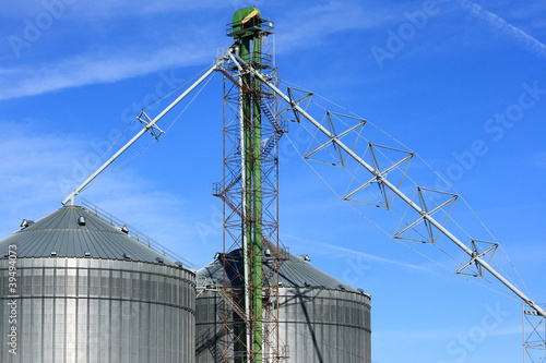 Metal Grain Bins Against A Blue Sky
