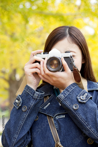 銀杏をカメラで撮る女性