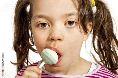 Quadro em tela Close-up of little girl with a lollipop, on white background