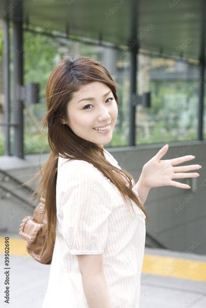 振り返って手を振る女性 振り返って手を振る女性