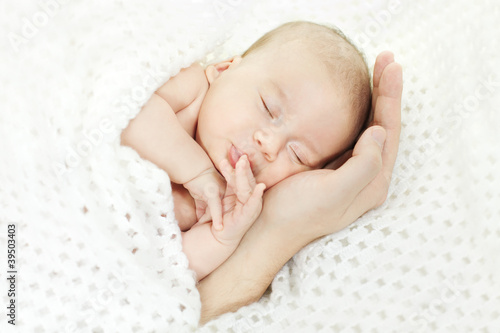 Newborn baby sleeping on parents hand © inarik