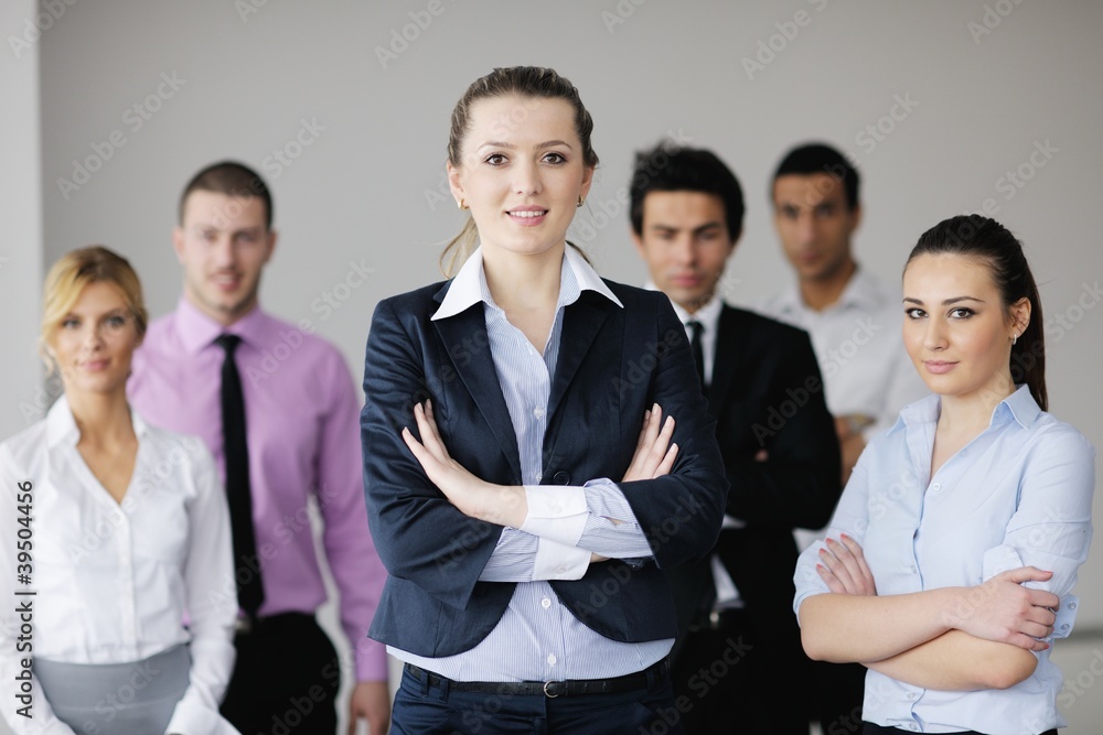 business woman standing with her staff in background business woman standing with her staff in background
