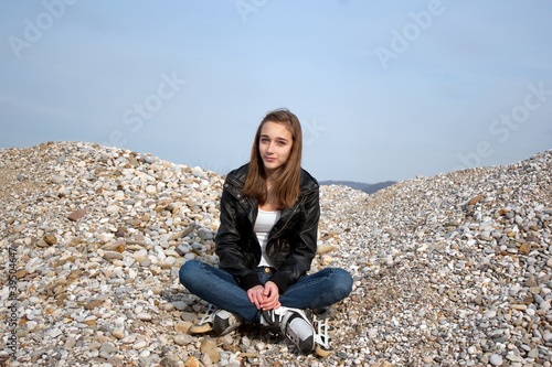 Teenage girl with rollerblades sitting on pebbles © Gordana Sermek