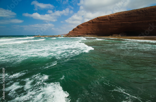 huge red cliffs with arches on the beach Legzira. Morocco