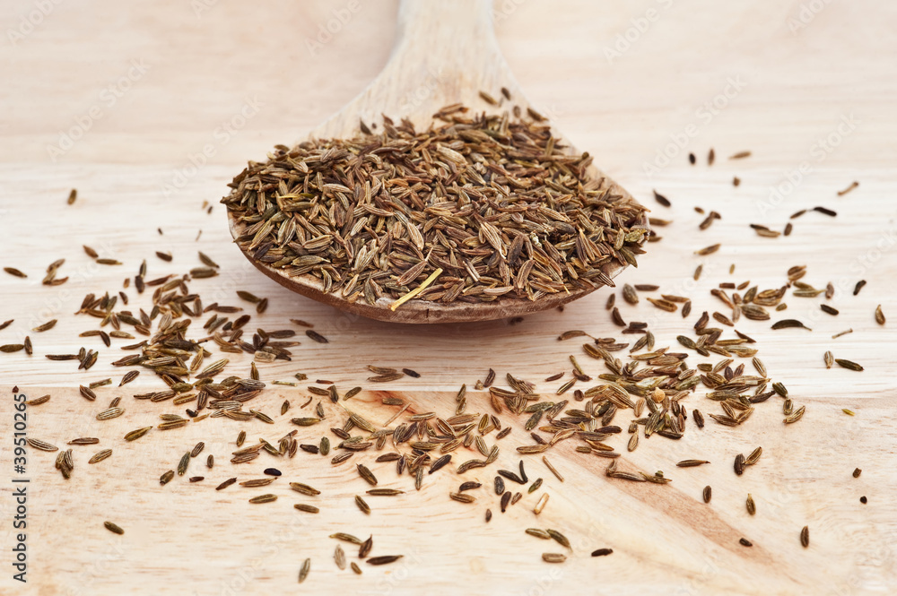Cumin Seeds on wooden serving spoon with selective focus Cumin Seeds on wooden serving spoon with selective focus