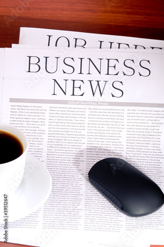 Business newspaper, cup of coffee and mouse