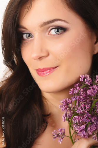 Beautiful women with lilac flowers and with purple makeup
