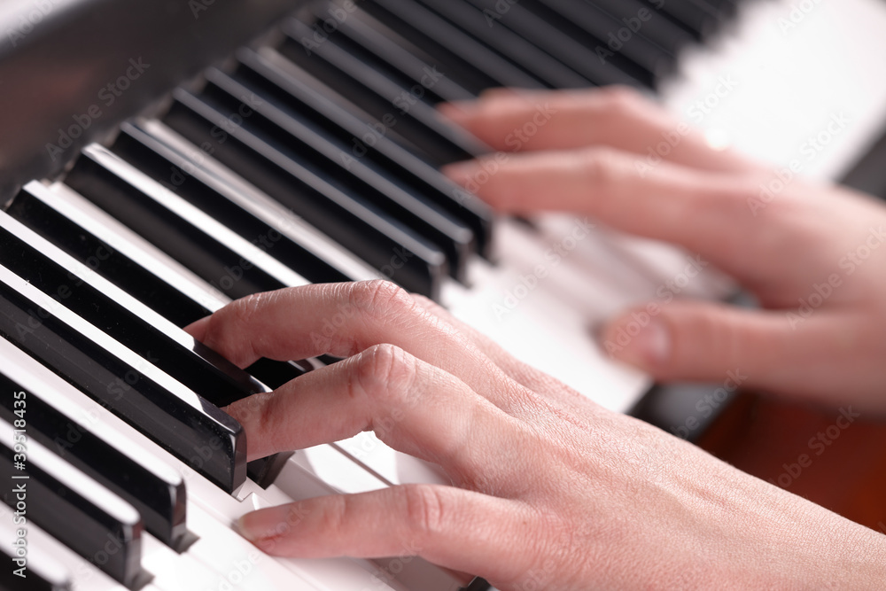 Woman's hands playing music on the piano Woman's hands playing music on the piano