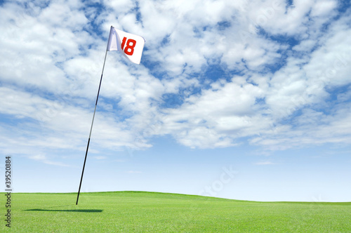 Golf flag at hole 18 on the putting green photo