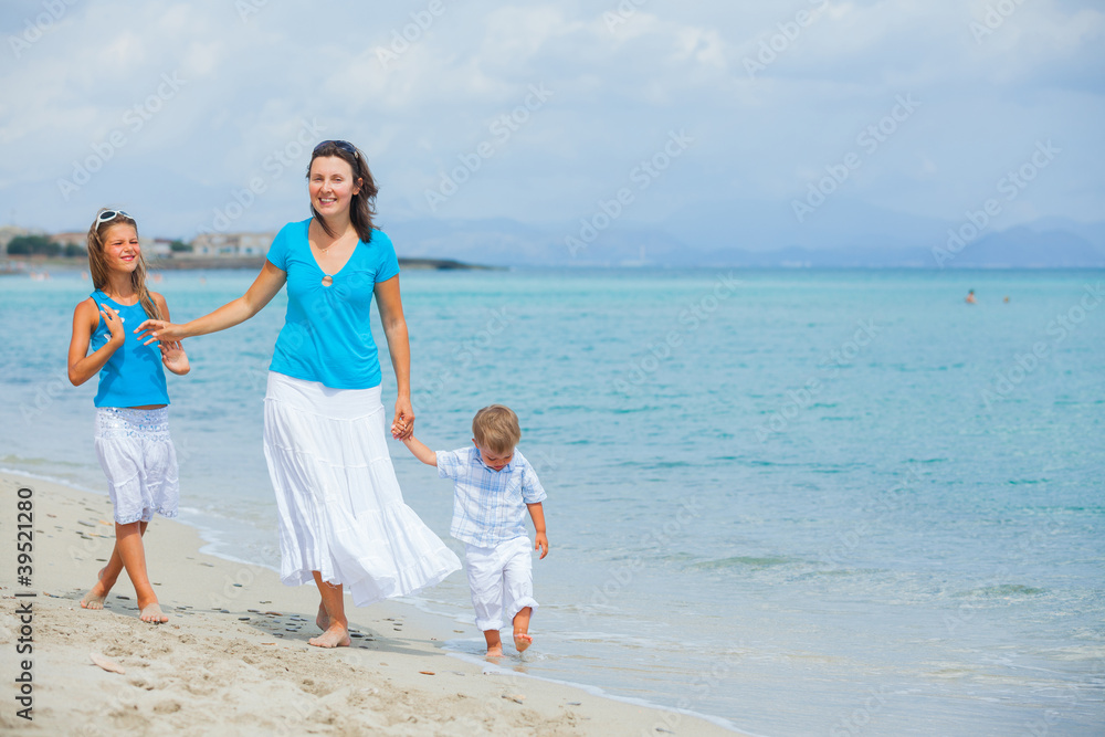 Mother and two kids having fun on beach
