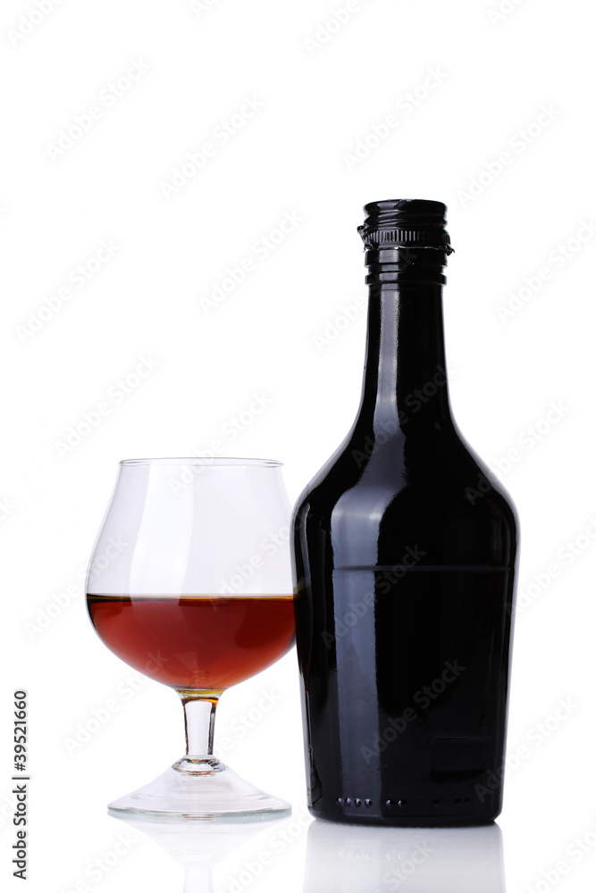 Glass of brandy and bottle isolated on white Glass of brandy and bottle isolated on white