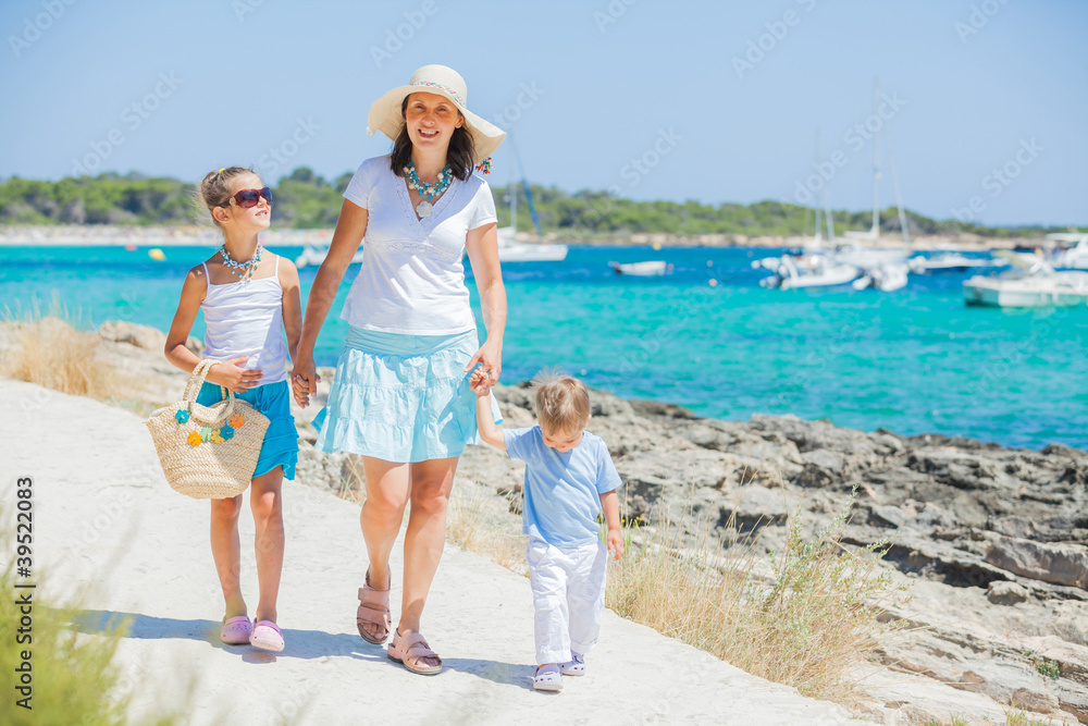 Family of three walking along tropical beach Family of three walking along tropical beach