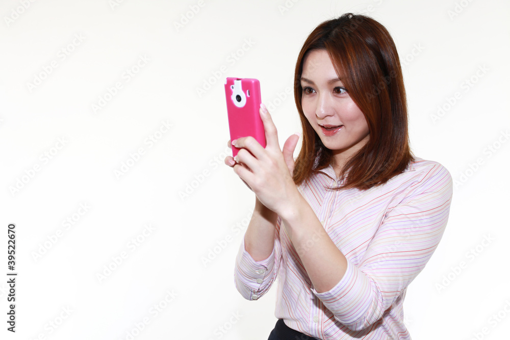 Naklejka premium スマートフォンを操作する笑顔のオフィスレディー