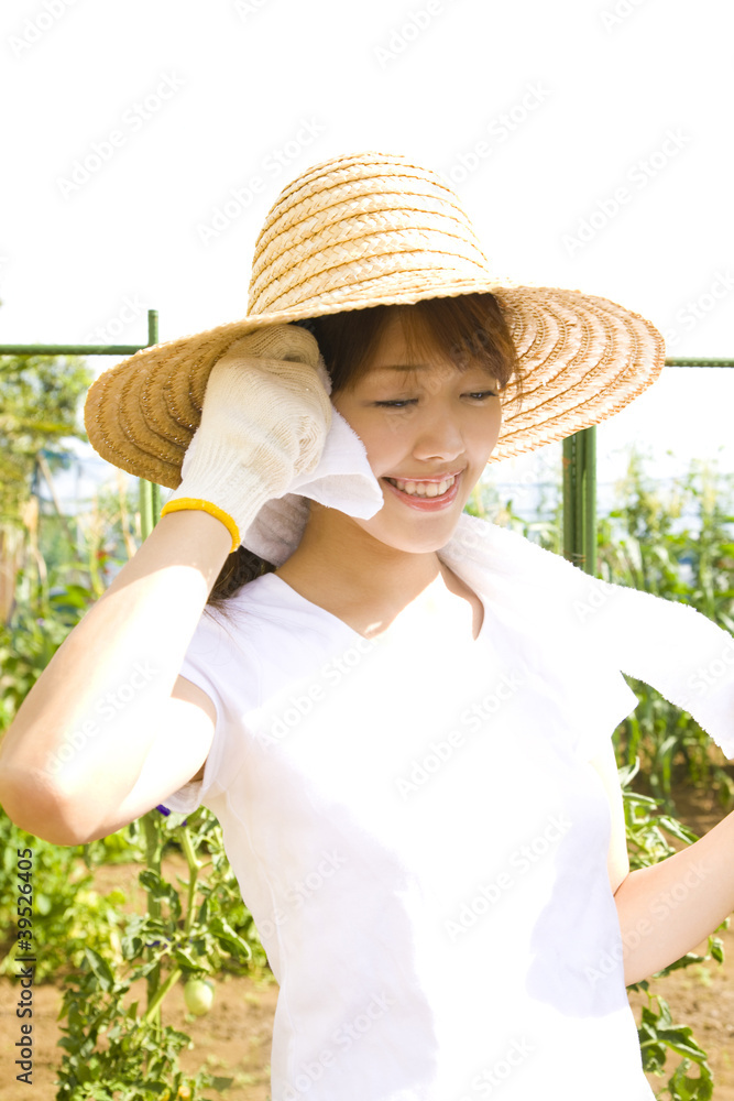 畑仕事中に汗を拭く女性
