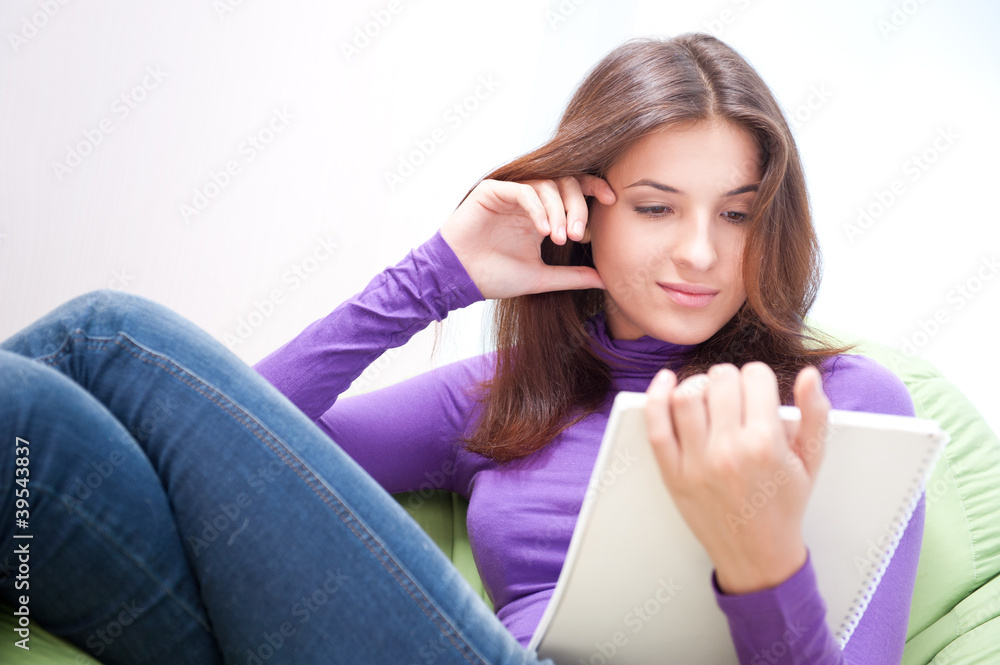 Young woman with copybook at her home Young woman with copybook at her home