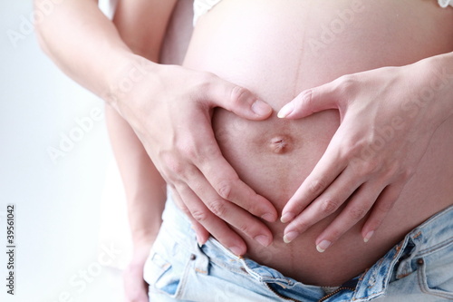Image of pregnant woman touching her belly with hands