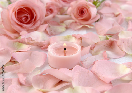 Romantic still-life with pink candle and rose petals