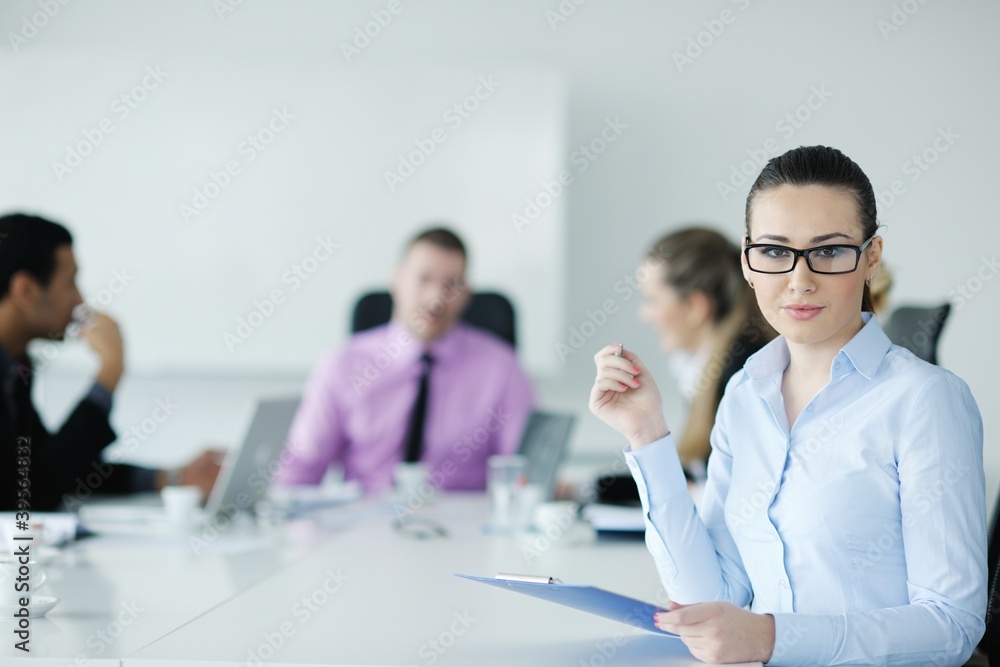business woman standing with her staff in background business woman standing with her staff in background