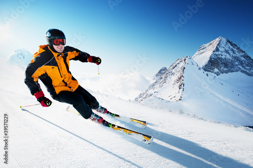 Skier in mountains  prepared piste and sunny day