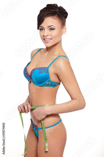 beautiful smiling woman in blue lingerie measuring  shape © halayalex